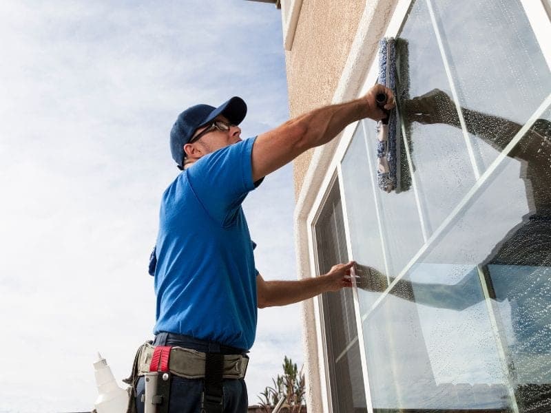 Glazenwasser wast de ramen van een woning met een inwasser